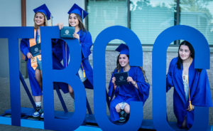 Graduates posing by letters TBCC 2021 Graduation